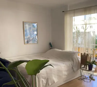 a white bedroom with a bed and a window at Océan front apartment in Cannes