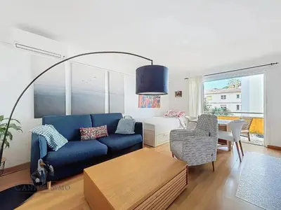 a living room with a blue couch and a table at Océan front apartment in Cannes