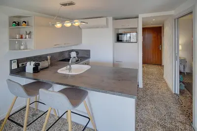 a kitchen with a sink and two bar stools at Le Louvre Top Floor in Cannes