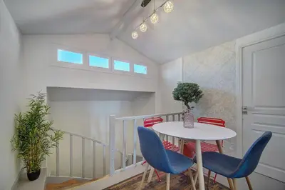 a dining room with a white table and blue chairs at Le Louvre Top Floor in Cannes