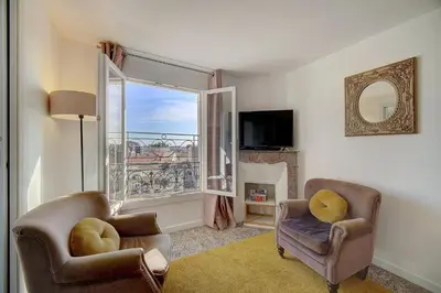 a living room with two chairs and a window at Le Louvre Top Floor in Cannes