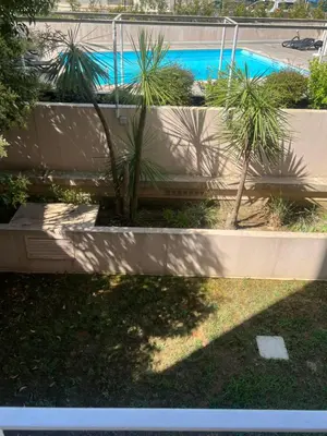 two pictures of a swimming pool with palm trees at PISCINE Plages à 100 m, palais des festivals à 15mn à pied dans la banane in Cannes