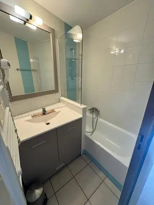 a bathroom with a sink and a tub and a mirror at PISCINE Plages à 100 m, palais des festivals à 15mn à pied dans la banane in Cannes
