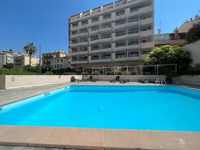a large blue swimming pool in front of a building at PISCINE Plages à 100 m, palais des festivals à 15mn à pied dans la banane in Cannes