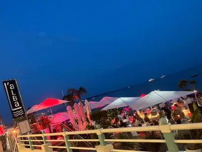 a crowd of people sitting under umbrellas on a beach at PISCINE Plages à 100 m, palais des festivals à 15mn à pied dans la banane in Cannes