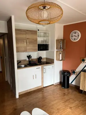 a kitchen with white cabinets and a clock on the wall at PISCINE Plages à 100 m, palais des festivals à 15mn à pied dans la banane in Cannes
