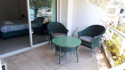 a patio with chairs and a table and a dog at Bright apartment - Cannes, la Croisette in Cannes