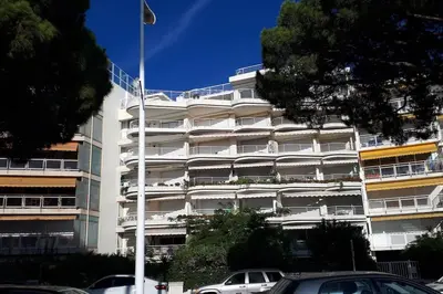a white building with cars parked in front of it at Bright apartment - Cannes, la Croisette in Cannes