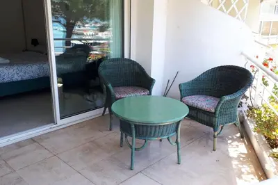 a table and two chairs and a dog looking out the window at Bright apartment - Cannes, la Croisette in Cannes