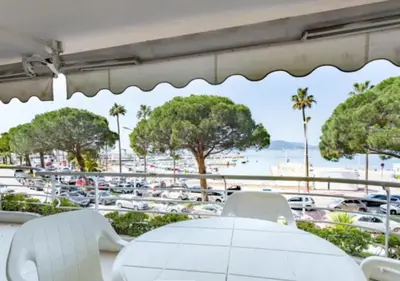 a table with chairs and a view of a parking lot at Bright apartment - Cannes, la Croisette in Cannes