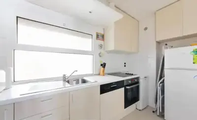 a white kitchen with a sink and a refrigerator at Bright apartment - Cannes, la Croisette in Cannes