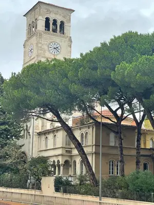 a building with a clock tower with a tree in front of it at Parc De La Croisette in Cannes