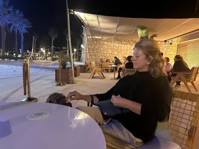 a woman sitting on a chair next to a table at Parc De La Croisette in Cannes