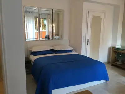 a bedroom with a blue bed with a window at Parc De La Croisette in Cannes