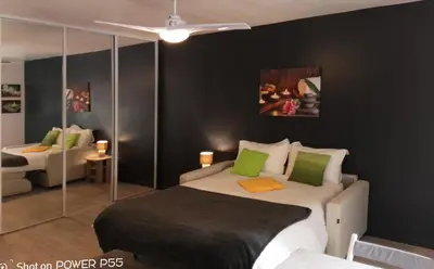 a bedroom with a bed with green pillows at CANNES - JOLI STUDIO AVEC BALCON in Cannes