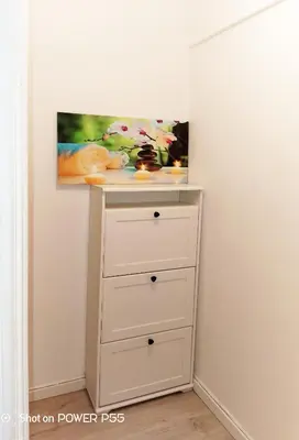 a white dresser with a painting on the wall at CANNES - JOLI STUDIO AVEC BALCON in Cannes