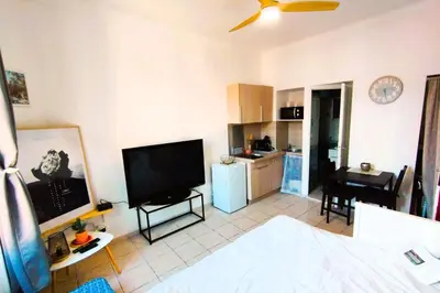 a living room with a television and a kitchen at Charming Studio ideal for Congresses and Holidays LIVE IN GAZAGNAIRE in Cannes