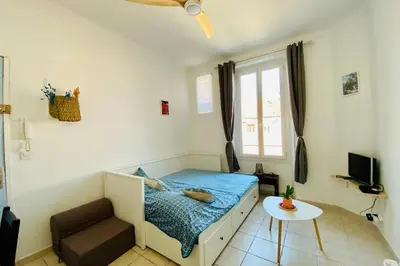 a small bedroom with a bed and a table at Charming Studio ideal for Congresses and Holidays LIVE IN GAZAGNAIRE in Cannes