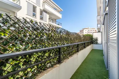 a fence with green plants on a balcony at La Villa Gauguin in Le Cannet