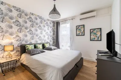 a bedroom with a large bed and a tv at La Villa Gauguin in Le Cannet