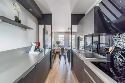 a kitchen with stainless steel counter tops and wooden floors at La Villa Gauguin in Le Cannet