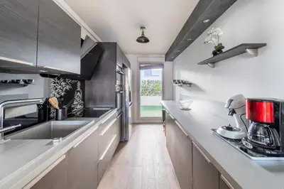 a kitchen with stainless steel appliances and wooden floors at La Villa Gauguin in Le Cannet