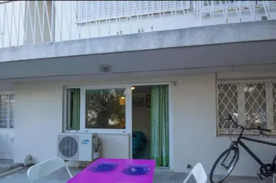 a pink table and a bike in front of a building at Studio at -La Croisette- Cannes - BEACH GARDEN - in Cannes