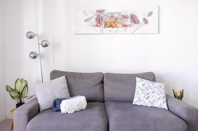 a gray couch with pillows in a living room at Cannes centre apartment with a balcony in Cannes