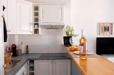 a kitchen with a bottle of wine on a counter at Cannes centre apartment with a balcony in Cannes