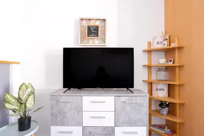 a television on a dresser in a living room at Cannes centre apartment with a balcony in Cannes