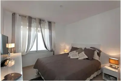 a bedroom with a large bed and a window at REF 912 - Cannes Center - Apartment for rent in Cannes