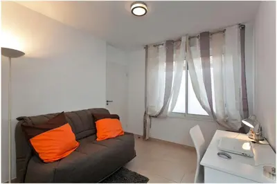 a living room with a couch and a table and a window at REF 912 - Cannes Center - Apartment for rent in Cannes