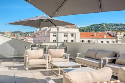 a patio with chairs and an umbrella on a roof at REF 1071 - Cannes Center - 5mins to the Palais des Festivals in Cannes