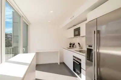 a white kitchen with a stainless steel refrigerator at REF 1071 - Cannes Center - 5mins to the Palais des Festivals in Cannes