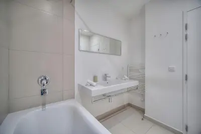 a white bathroom with a tub and a sink at REF 909 - Cannes Back Croisette - Apartment for rent in Cannes
