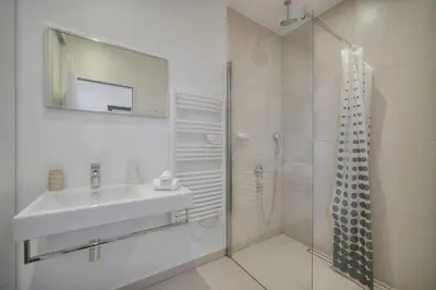 a white bathroom with a sink and a shower at REF 909 - Cannes Back Croisette - Apartment for rent in Cannes