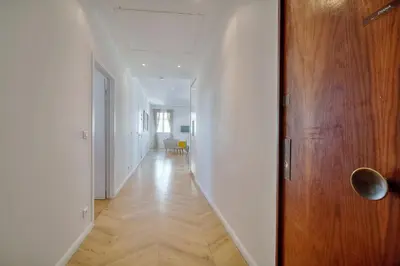 a hallway with a wooden door and a white wall at REF 909 - Cannes Back Croisette - Apartment for rent in Cannes