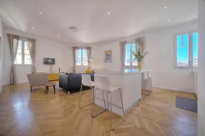a living room with a bar and a table and chairs at REF 909 - Cannes Back Croisette - Apartment for rent in Cannes