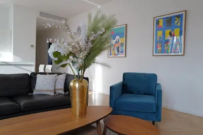 a living room with a couch and a vase with flowers at REF 909 - Cannes Back Croisette - Apartment for rent in Cannes