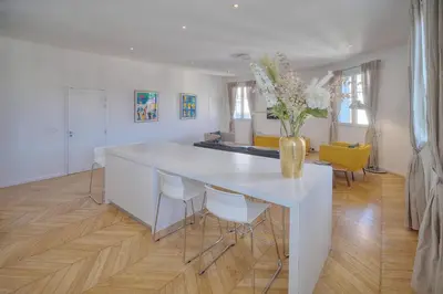 a white table with chairs and a vase with flowers at REF 909 - Cannes Back Croisette - Apartment for rent in Cannes