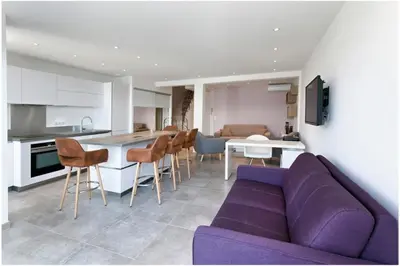 a living room with a purple couch and a kitchen at REF 1229 - Cannes Croisette - Sea view apartment for rent in Cannes