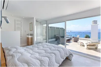 a large white bedroom with a large bed and a balcony at REF 1229 - Cannes Croisette - Sea view apartment for rent in Cannes