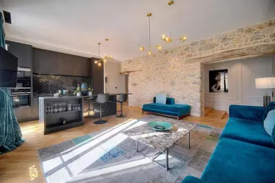 a living room with a blue couch and a kitchen at REF 1393 - Cannes Center - Apartment for rent in Cannes