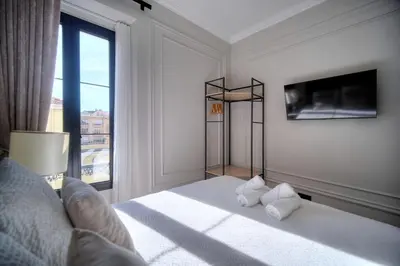 a white room with a bed and a large window at REF 1393 - Cannes Center - Apartment for rent in Cannes