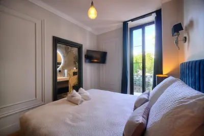 a bedroom with a bed with a mirror and a window at REF 1393 - Cannes Center - Apartment for rent in Cannes