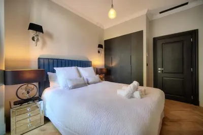 a bedroom with a large bed with white sheets and pillows at REF 1393 - Cannes Center - Apartment for rent in Cannes