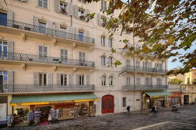 a building with balconies on a street with a store at REF 1393 - Cannes Center - Apartment for rent in Cannes