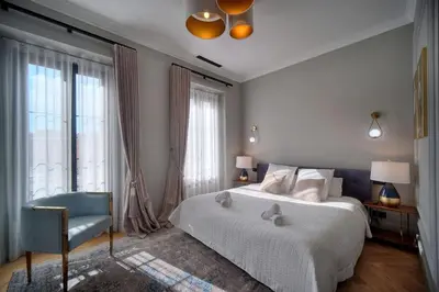 a bedroom with a bed and a chair and windows at REF 1393 - Cannes Center - Apartment for rent in Cannes
