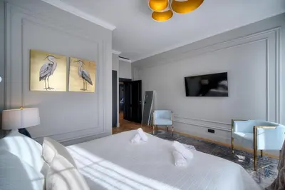 a white bedroom with a bed and two chairs at REF 1393 - Cannes Center - Apartment for rent in Cannes
