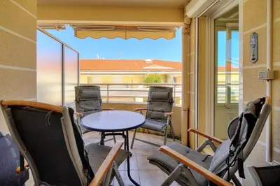 a balcony with chairs and a table and a window at REF 1766 - Cannes Center - Apartment for rent in Cannes